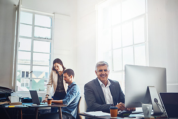 Image showing Portrait, business and senior man by computer in office workplace. Pc, coworking and happy elderly male employee working on marketing report, advertising or sales project with colleagues in company.