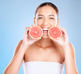 Image showing Skincare, beauty and portrait of a woman with grapefruit for a natural, organic and healthy face routine. Cosmetic, wellness and girl model from Mexico with a tropical citrus fruit by blue background