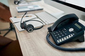 Image showing Telemarketing office, phone and VOIP on desk for communication, contact us and consulting by computer. Modern office, telephone and headphones on table for customer support, help or service with pc