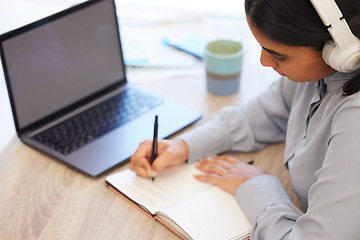 Image showing Laptop, notebook and woman writing notes while doing research for marketing project in office. Headphones, technology and creative female employee planning advertising strategy and listening to music