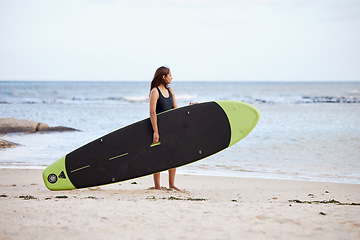 Image showing Relax, woman or surfer at a beach on holiday with a surfboard for fitness training, cardio exercise or workout. Freedom, Thinking or sports girl looking at ocean waves for surfing opportunity at sea