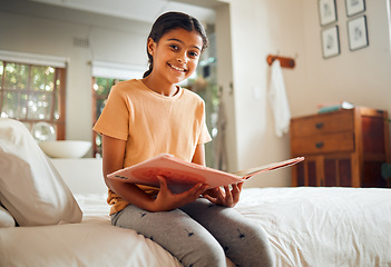 Image showing Happy little girl, reading book and bed with smile for story time, education or learning in comfort at home. Portrait of cute female child smiling in happiness holding textbook to read in the bedroom