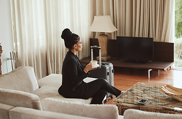 Image showing Travel, coffee and business woman in a bedroom relaxing, thinking and drinking a cup of caffeine. Career, luggage and professional corporate female sitting in hotel enjoying a warm drink on work trip