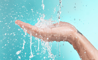 Image showing Beauty, cleaning and hand of man with water splash for self care, wellness and cosmetic campaign. Health, hygiene and shower skincare hydration model washing zoom in blue studio background.