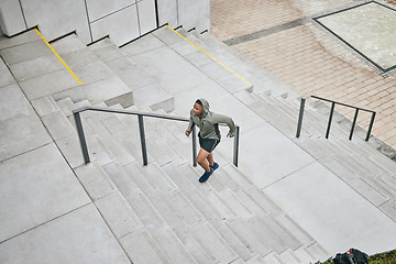 Image showing Running, stairs and city with a sports black man from above for a cardio or endurance workout for fitness. Training, exercise or motivation with a male runner or athlete moving up an urban staircase