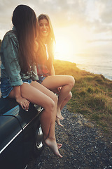 Image showing Women friends, road trip and sunset in nature for travel, adventure and freedom while happy outdoor. Funny girls on a car while talking on vacation drive or journey with transport and ocean view