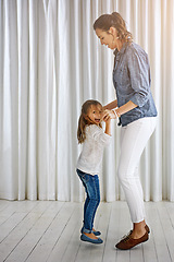 Image showing Dance, family and mother with girl in a living room for fun, bonding and teaching dancing steps in their home. Love, mom and daughter playing, laughing and relax in their lounge, weekend and positive