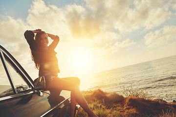 Image showing Woman, sunset portrait and road trip on hood of car with smile, beach or happiness for summer vacation. Happy gen z girl, sky and sunshine with nature, outdoor adventure and holiday by ocean in Miami