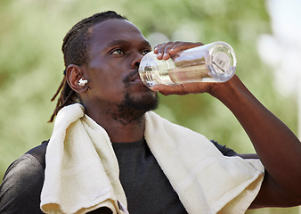 Image showing Water, fitness break and black man running in nature, exercise hydration and focus on body performance in Germany. Thirsty, training and African runner thinking of cardio workout in park with a drink