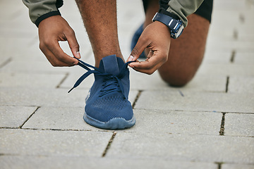 Image showing City, hands and black man tie shoes and preparing for running, workout or exercise. Wellness, sports fitness and male runner tying sneaker lace and getting ready for training jog on street outdoors.