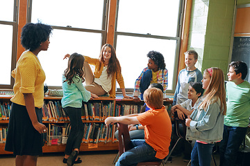 Image showing Education library, teacher and children students in classroom of elementary school. Development, learning scholarship and group of kids talking, discussion and studying for knowledge with black woman