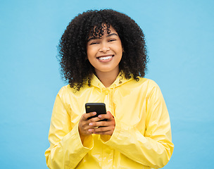 Image showing Black woman, portrait and phone with a person smile with blue studio background, Isolated, happiness and social media mobile communication of a female ready to text and connect on a cellphone