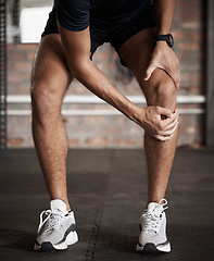 Image showing Knee injury, pain and fitness with a sports man holding his joint during a workout routine in the gym. Anatomy, accident and exercise with a male athlete injured while training in a health club