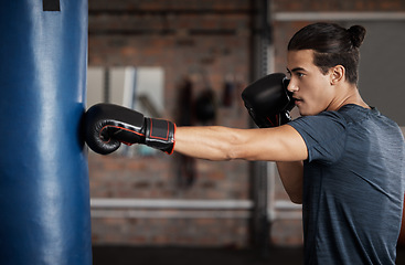 Image showing Boxing, exercise and man with focus for fight training and gym fitness ready for sports. Workout, wellness and health club with a young male athlete and boxer in a ring with punching bag alone