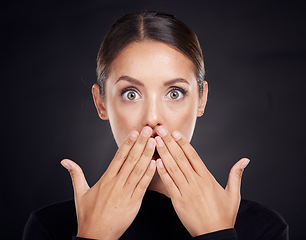 Image showing Woman, portrait and hands on mouth for wow, shock and makeup for beauty, cosmetics and black background. Model, face and surprise eyes with dark aesthetic, skin glow and results by studio backdrop