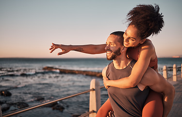 Image showing Fitness, couple and piggyback for beach sunset, travel or fun holiday journey together in the outdoors. Happy man and woman enjoying back ride by the ocean coast after running exercise or workout