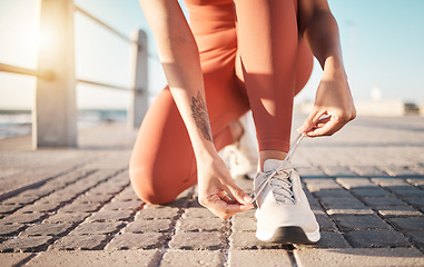 Image showing Shoelace, fitness and woman ready for running, sports and training on the ground in Puerto Rico. Motivation, performance and feet of a runner tying laces to start a marathon and cardio workout