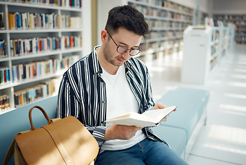 Image showing Education, man and student reading in library, knowledge and studying for exams, test and intelligent. Young male, guy and academic with book, learning and university study area, peace and creative