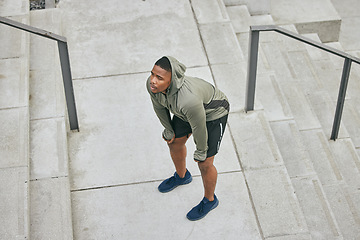 Image showing Breathe, tired and sweating black man, athlete and fitness break on stairs of city workout. Top view of runner, breathing and sports fatigue on steps of training challenge, exercise or cardio running