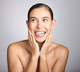 Image showing Face, beauty and tongue with a model woman in studio, thinking about skincare on a gray background. Idea, facial and playful with an attractive young female posing to promote natural skin treatment