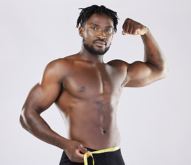 Image showing Muscular black man, tape measure and isolated flexing on a grey background for fitness, weight loss or dieting. Portrait of African American male muscle flex, healthy body or empowerment