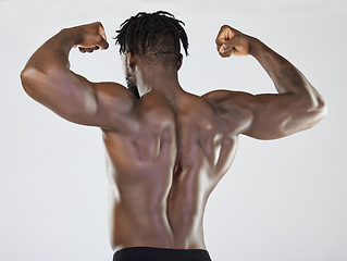 Image showing Back, body and biceps with a model black man posing in studio on a gray background for fitness or exercise. Muscle, health and wellness with a strong male athlete standing or flexing for power