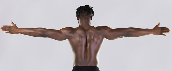 Image showing Back, arms and muscular with a model black man posing in studio on a gray background for fitness or exercise. Muscle, health and wellness with a strong male athlete standing or flexing for power
