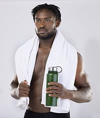 Image showing Exercise, fitness and black man with a towel and water for sports training in studio. Health and wellness of a sexy male bodybuilder model thinking about workout, goal and body progress with a bottle