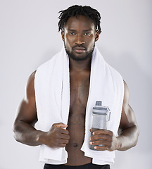 Image showing Black man, towel and water for fitness portrait of sports person in studio for strong body. Health and wellness of sexy male bodybuilder model after exercise, workout and power training with a bottle