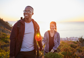 Image showing Interracial couple, workout and hiking exercise in sunset on a mountain as morning fitness in nature. Happy people, man and woman in a relationship training for health and wellness together