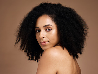 Image showing Portrait, beauty and afro with a model black woman in studio on a brown background for natural skincare. Face, cosmetics and hair with an attractive young female posing to promote cosmetics