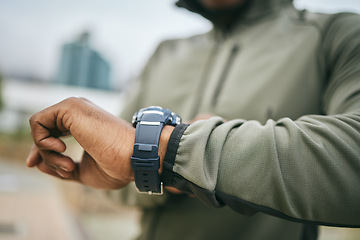 Image showing Fitness, training and hand of a man with a watch for progress, exercise monitor and tracking health in Germany. Goal, performance and runner reading the time after running for cardio in the city