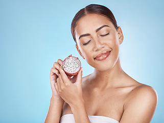 Image showing Skincare, nutrition and woman with a dragon fruit for beauty, body health and cosmetic diet on a blue background in studio. Detox food, marketing and model advertising a fruit for healthy skin