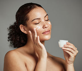 Image showing Black woman, face and skincare cream for beauty wellness shine, cosmetics dermatology and salon spa product in studio. African girl hands, facial moisturizer and spf sunscreen or luxury makeup glow