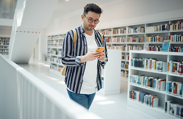 Image showing Education, social media and man with a phone in a library for communication, wifi connection and online chat at college. University, learning and student with a mobile for research and typing email