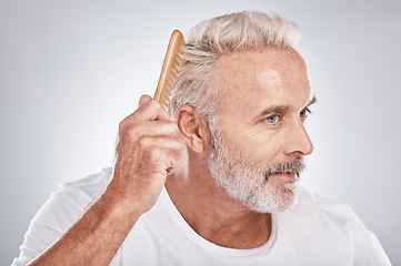 Image showing Senior man, hair comb and brush on studio background for beauty, barber salon and cosmetics. Face of male model, brushing hairstyle and fashion for manly grooming, hair care and fresh morning routine