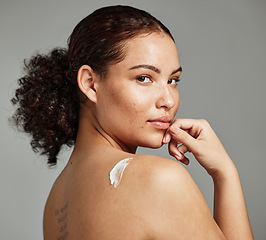 Image showing Portrait, back and woman with cream, skincare and dermatology for wellness, health and against grey studio background. Latino female, girl and lotion for cosmetics, natural beauty and smooth skin