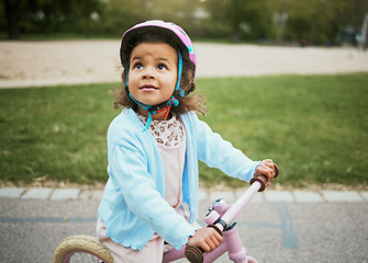 Image showing Cycling, fun and child on a bike in the park, outdoor activity and learning in New Zealand. port, happiness and girl kid playing on a bicycle ride in the neighborhood street or road in childhood