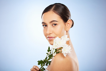 Image showing Face portrait, skincare and woman with flower in studio on a blue background mockup. Organic makeup, floral cosmetics and female model with white plant for facial treatment, healthy skin and beauty.