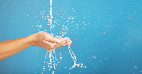 Image showing Cleaning, save and hands with water for hygiene, grooming and washing body on a blue background. Shower, beauty and person saving liquid for health, wellness and mockup space on a studio backdrop