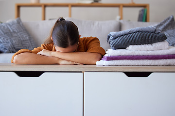 Image showing Woman, stress or laundry in home living room, apartment or hotel for housekeeping, health cleaning or hygiene maintenance. Burnout, anxiety or tired maid and clothes, fabric or folded washing on sofa