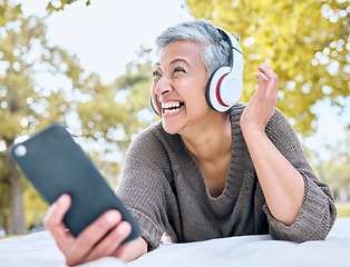 Image showing Music, headphones and senior woman with phone at park streaming radio or podcast. Thinking, cellphone and happy, elderly and female in retirement enjoying audio while laughing at comic meme.