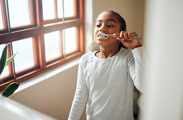 Image showing Girl brushing teeth, dental and toothbrush for hygiene with clean mouth and fresh breath with oral health. Kid, cleaning with toothpaste in bathroom and wellness at family home with healthy gums