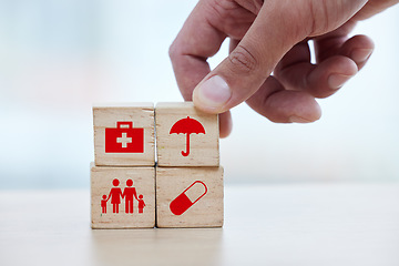 Image showing Family, healthcare and hand with blocks for insurance, medical future and investment in health. Medicine, safety and doctor building a hospital plan for security, service and trust in pharmacy