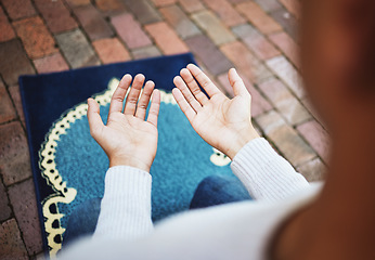 Image showing Hands, islam and praying in worship to Allah, god or creator on salah mat making dua on the floor. Hand of islamic man in pray for muslim religion, spiritual or respect for belief or culture outside