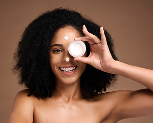 Image showing Portrait, container and beauty with a model black woman in studio on a brown background for skin treatment. Face, product and skincare with an attractive young female posing to promote antiaging care