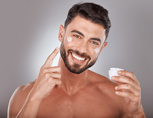 Image showing Man, skincare and cream in studio portrait with smile, happiness or self care by grey gradient backdrop. Cosmetic model, skin glow or luxury dermatology product in hand for wellness, facial or health