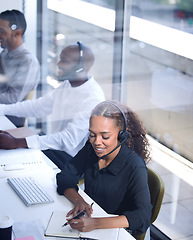 Image showing Call center, customer support with a happy black woman consultant working in her telemarketing office. Contact us, crm and communication with a female consulting using a headset from above