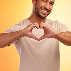 Image showing Portrait, heart and hands of man in studio isolated on a yellow background. Love, romance and happy male model with hand gesture for romantic emoji, care symbol or kindness, support or thank you.