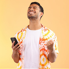 Image showing Winner, celebration and man with phone in studio isolated on yellow background. Winning, cellphone or happy male model holding mobile smartphone while celebrating goals achievement, target or success